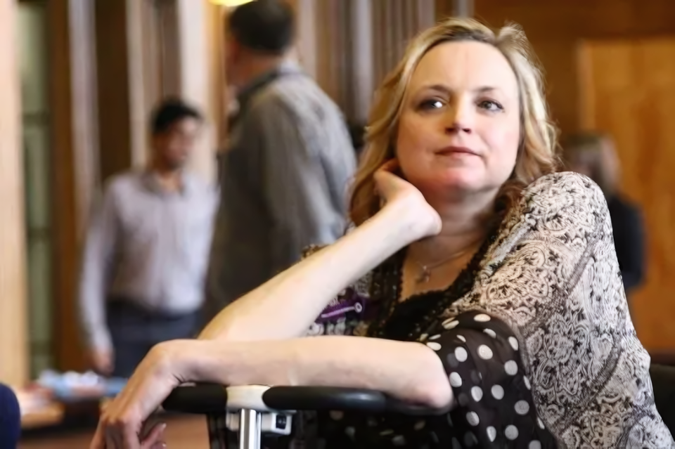 Photo of Amanda Heenan at an event, with other people in the background, photo courtesy of Amanda